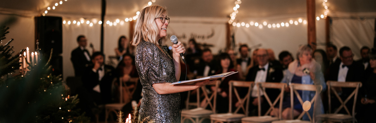 Sam White stood in a marquee speaking with a microphone