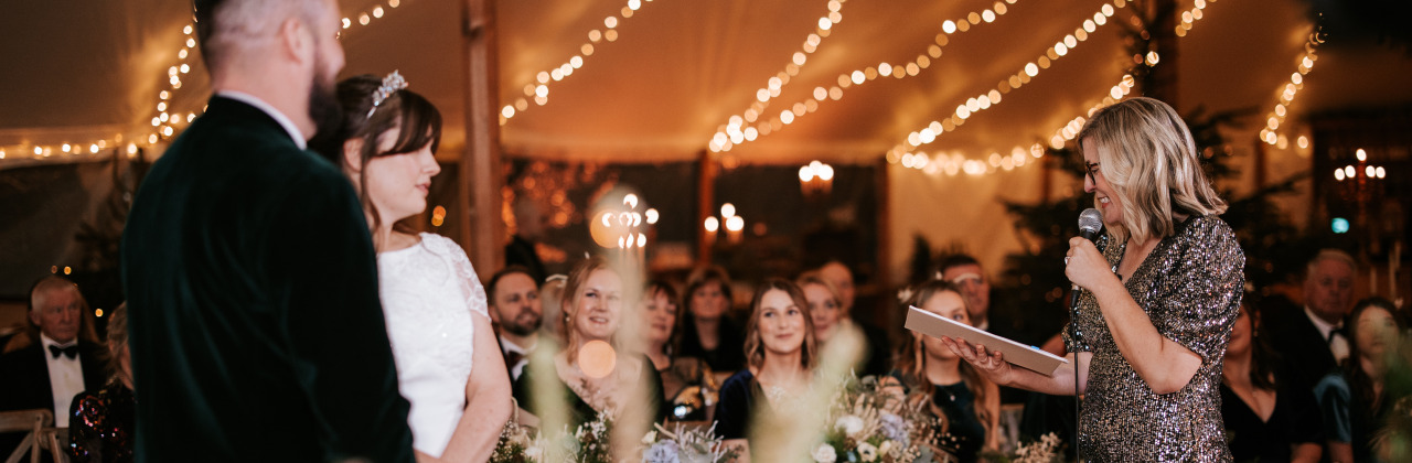 Sam White stood in a marquee speaking with a microphone