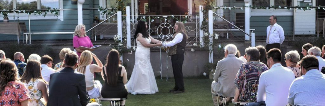 A man and woman taking part in a hand fasting cerfemony