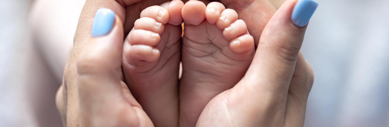 A pair of hands holding baby feet