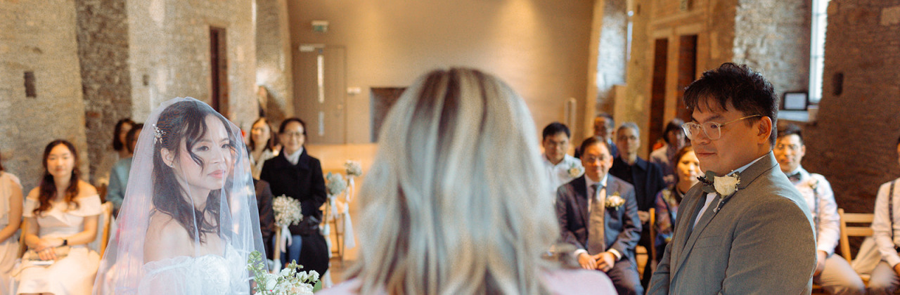 A woman stood with a bride and groom
