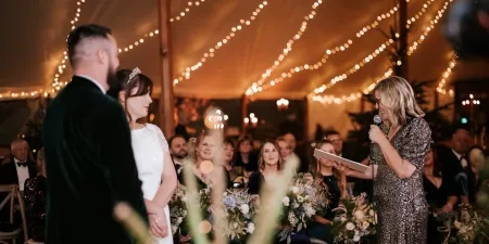 Sam White stood in a marquee speaking with a microphone