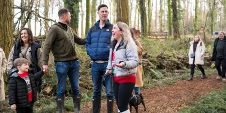 A group of people walking in a woodland with surprised expressions