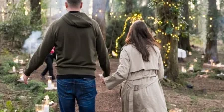 A man and woman walking away holding hands