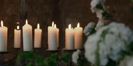 A close-up of some glowing white candles in the ceremony room at Ivy Lodge in Circencester.