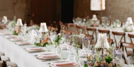 A photo of Tockington Park - a barn wedding venue near Bristol all set up for a wedding breakfast with long tables beautifully laid out with flowers.