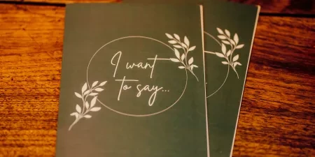 A photo of two vow booklets on a wooden table just before being spoken by a couple at their wedding.