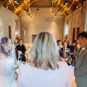A woman stood with a bride and groom
